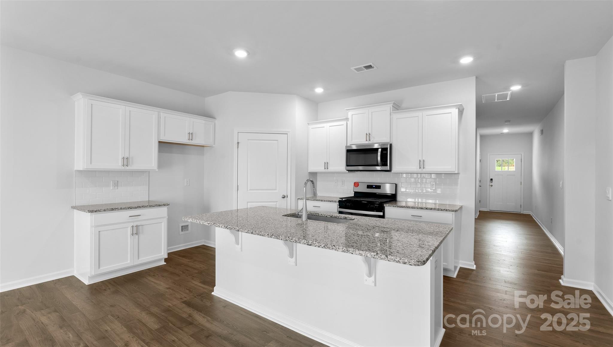 111 Ridgehaven Drive Waynesville, NC 28786 - Photo 4 of 21 a kitchen with stainless steel appliances granite countertop a sink a stove a refrigerator and white cabinets