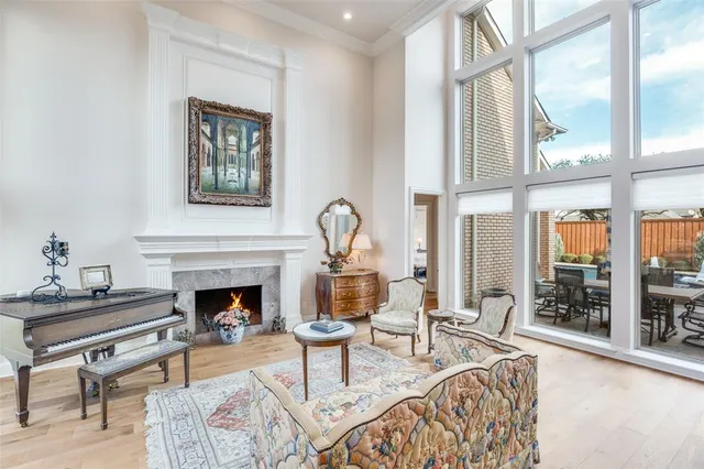 a living room with furniture a fireplace and a floor to ceiling window