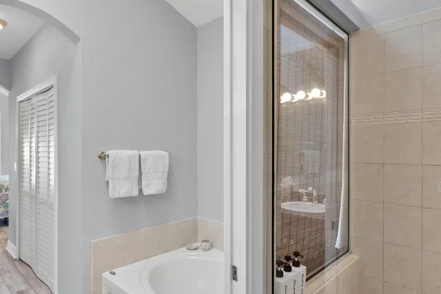a bathroom with a sink and mirror with bathtub