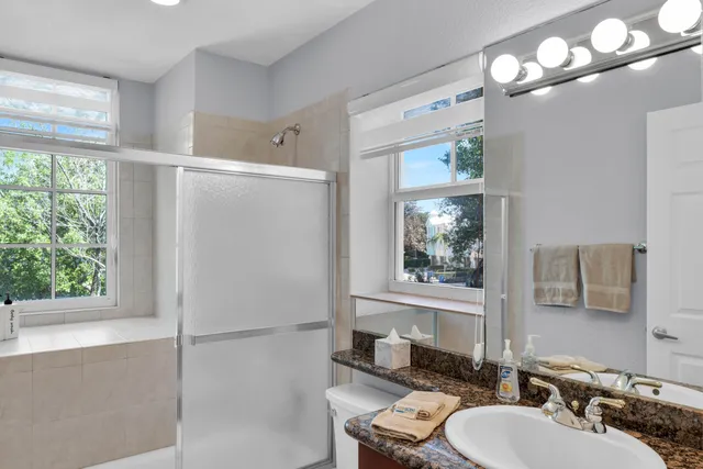 a bathroom with a double vanity sink mirror and toilet