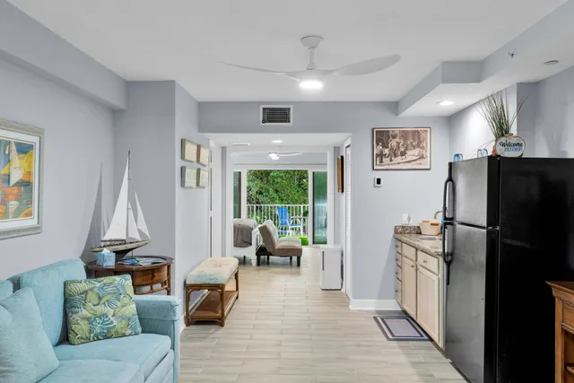 a living room with furniture and a refrigerator