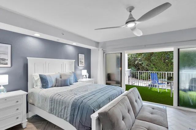 a bedroom with a balcony a bed and a large window