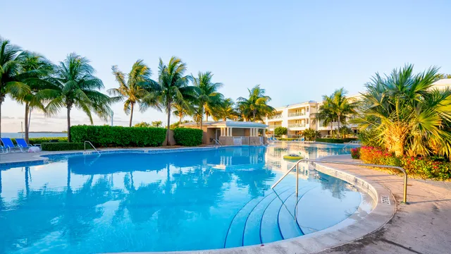 a living room with stainless steel appliances furniture a refrigerator and kitchen view