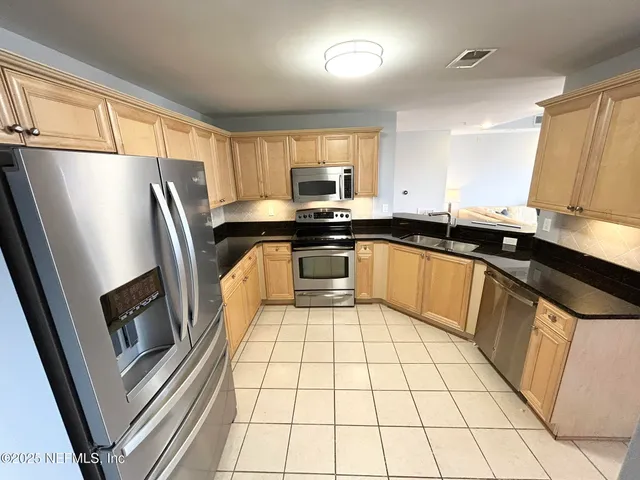a kitchen with a sink a stove and cabinets