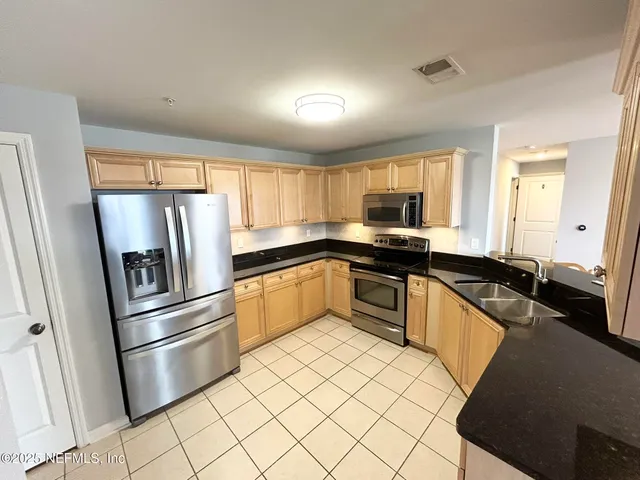 a kitchen with a refrigerator sink and stove top oven