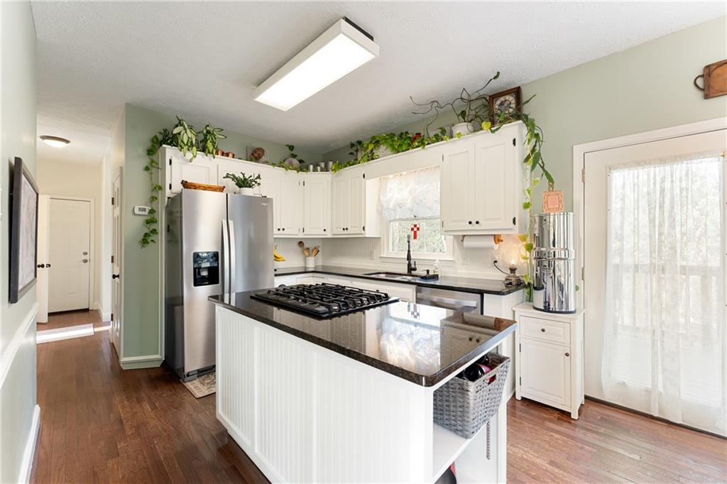 402 Hunters Court Ball Ground, GA 30107 - Photo 28 of 56 a kitchen with a stove a refrigerator and a wooden floor