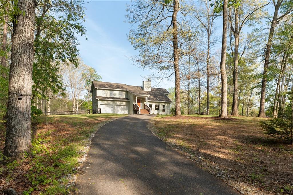 402 Hunters Court Ball Ground, GA 30107 - Photo 32 of 56 a front view of a house with a yard and garage