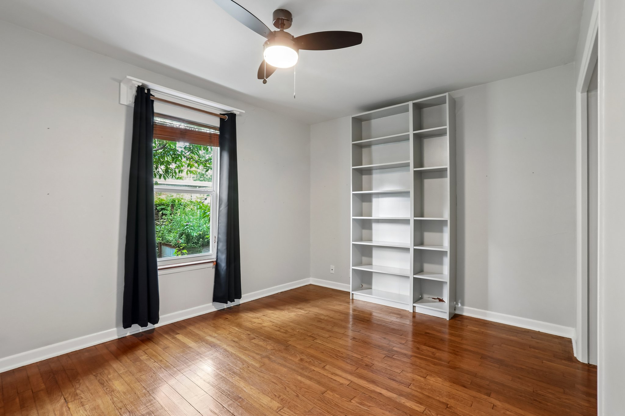 1114 West 2nd Street Elgin, TX 78621 - Photo 12 of 31 Bright hardwood floors and a built-in bookcase create an inviting, functional room.