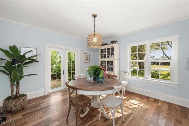 a dining room with furniture potted plants and wooden floor