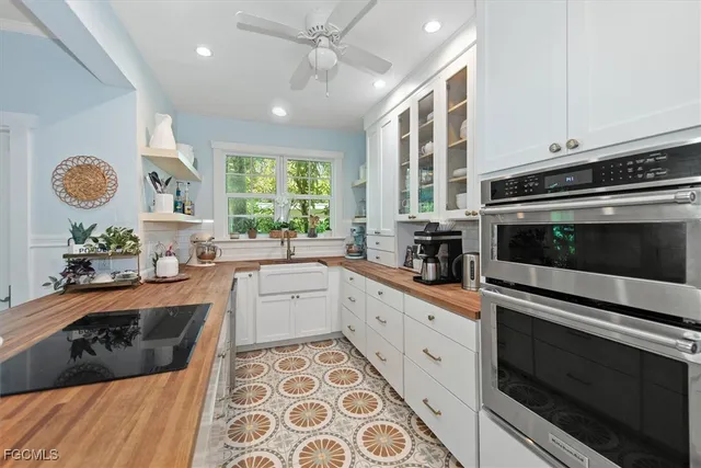a kitchen with granite countertop stainless steel appliances a stove a sink a window cabinets and a window