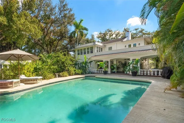 a view of a swimming pool with a patio and plants