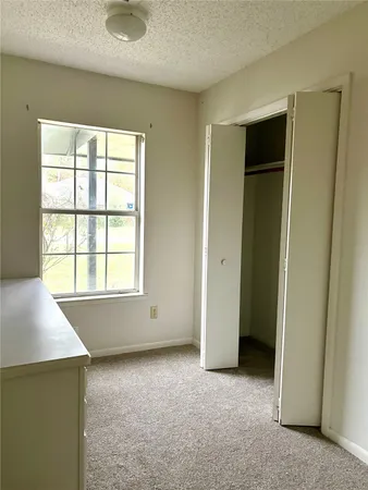 an empty room with windows and closet