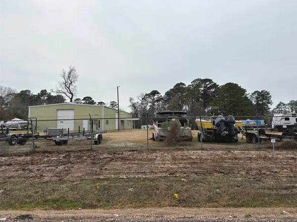 a view of a blue house with large trees and outdoor space