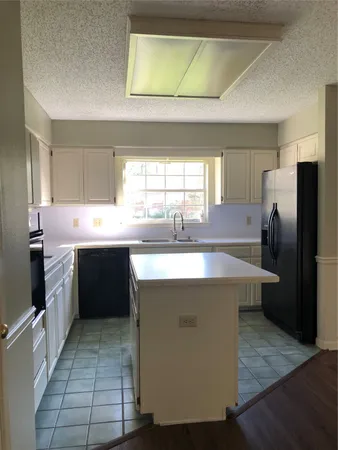 a kitchen with stainless steel appliances a sink window and a refrigerator