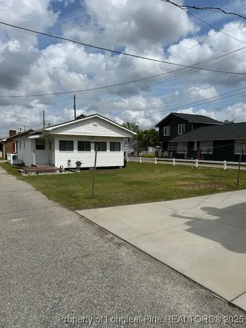 a view of a big house with a big yard and large trees