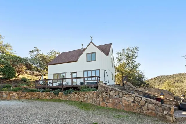 an aerial view of a house with a mountain