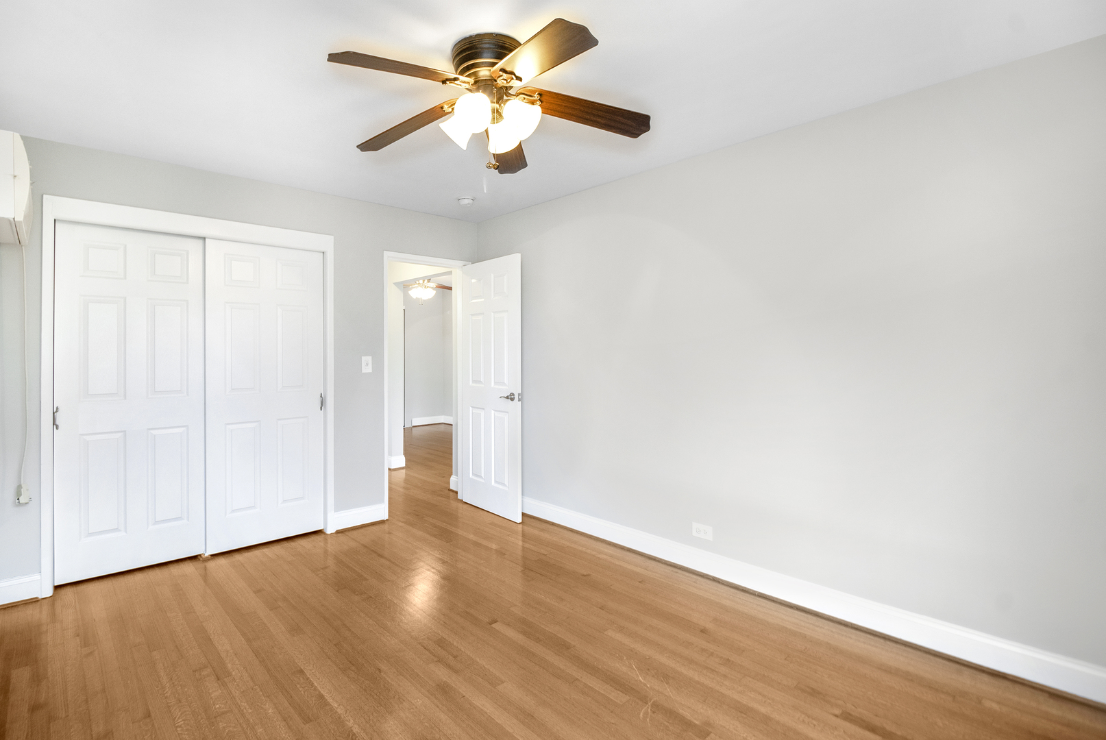 1951 Euclid Avenue, Unit 202 Berwyn, IL 60402 - Photo 14 of 16 an empty room with wooden floor chandelier fan and closet area