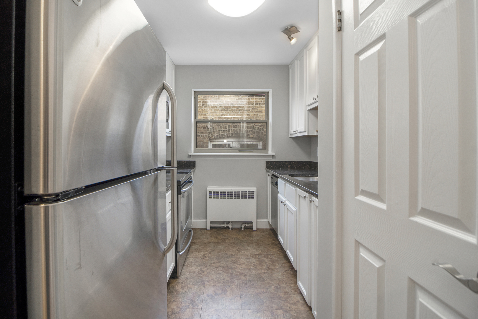 1951 Euclid Avenue, Unit 202 Berwyn, IL 60402 - Photo 4 of 16 a kitchen with a refrigerator a stove top oven and cabinets