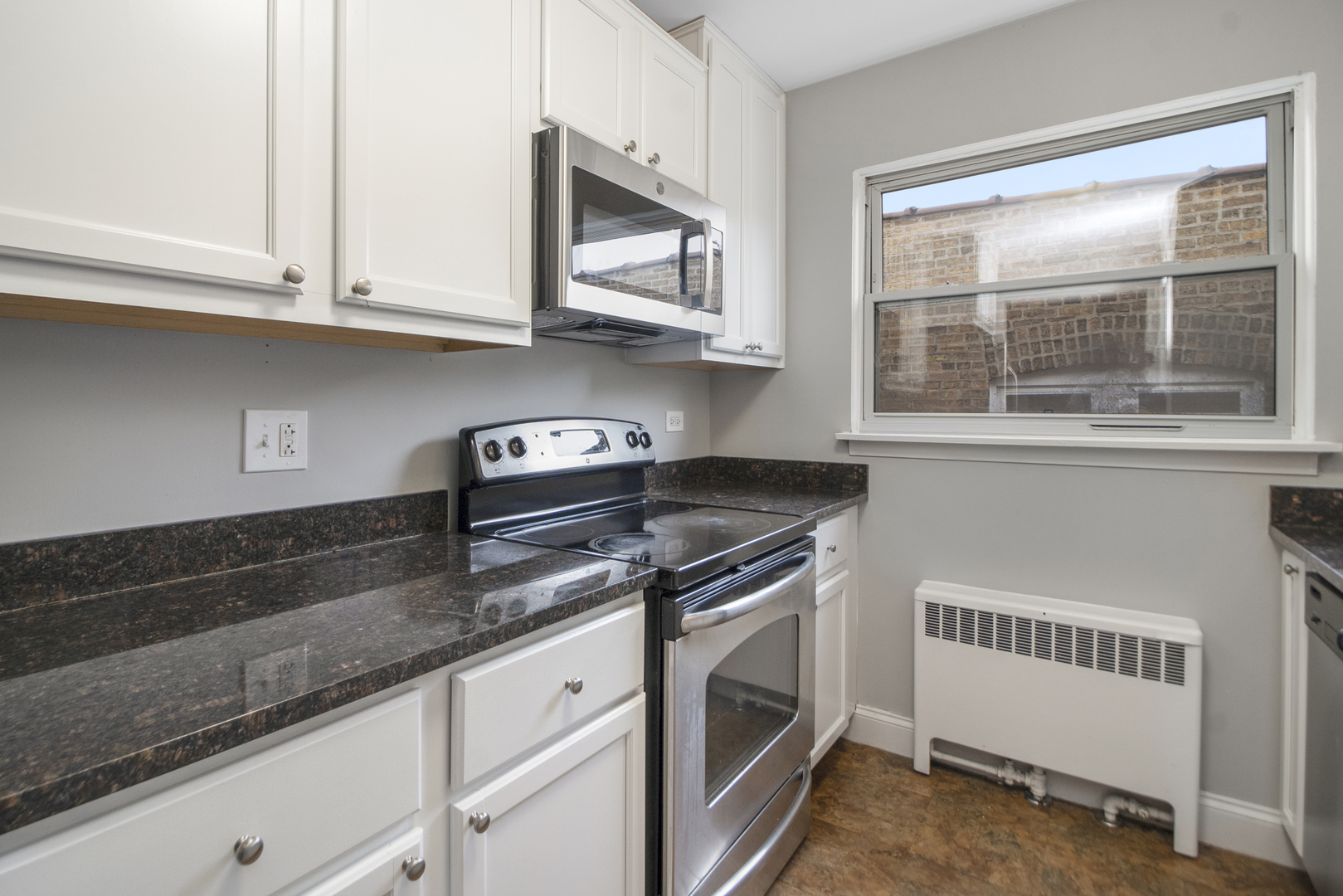 1951 Euclid Avenue, Unit 202 Berwyn, IL 60402 - Photo 5 of 16 a kitchen with stainless steel appliances granite countertop white cabinets and window