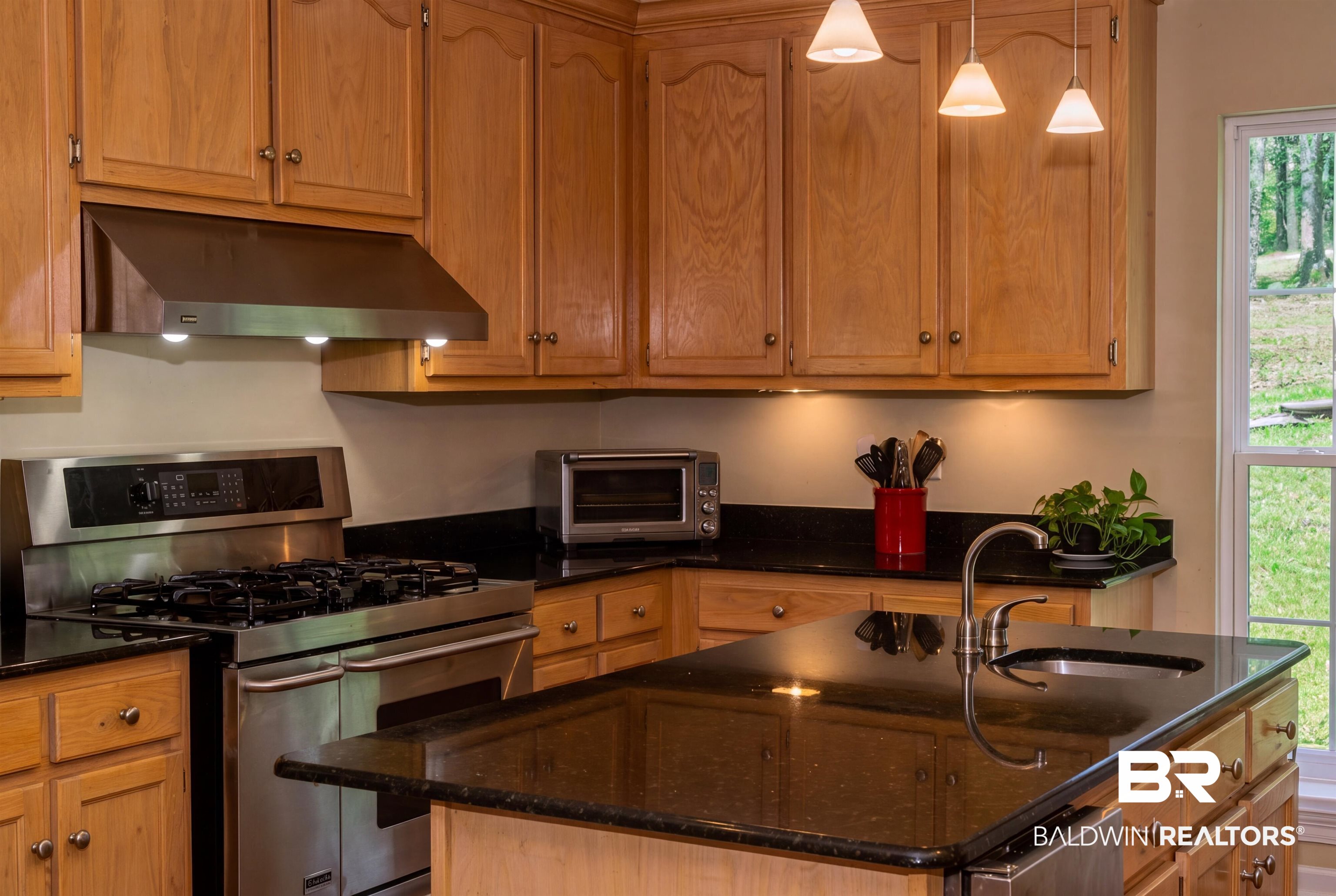 8008 Patricks Landing Road Bay Minette, AL 36507 - Photo 5 of 33 Kitchen featuring wood cabinetry, dark countertops, a stainless steel range with matching range hood, and a kitchen island with an integrated sink