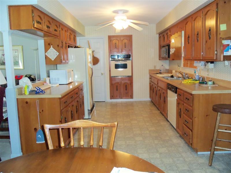 1219 Loggers Road Goodview, VA 24095 - Photo 8 of 21 a kitchen with stainless steel appliances granite countertop a stove a sink dishwasher and a refrigerator with wooden floor