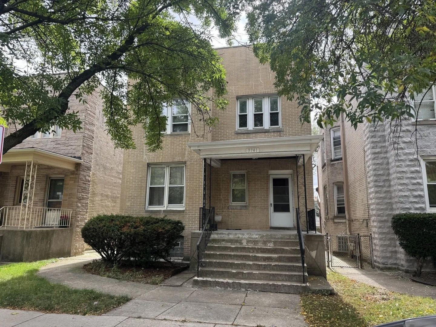 a view of a house with a yard and large tree