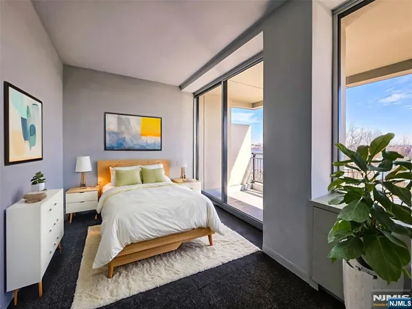 a bedroom with a bed table flowerpot and a window