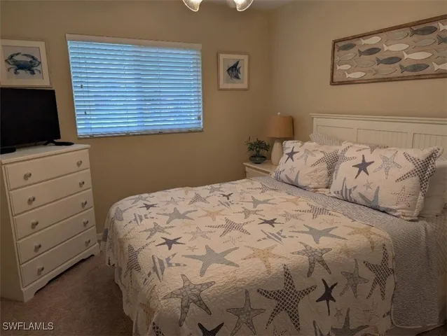 a bedroom with a large bed and a flat tv screen on dresser