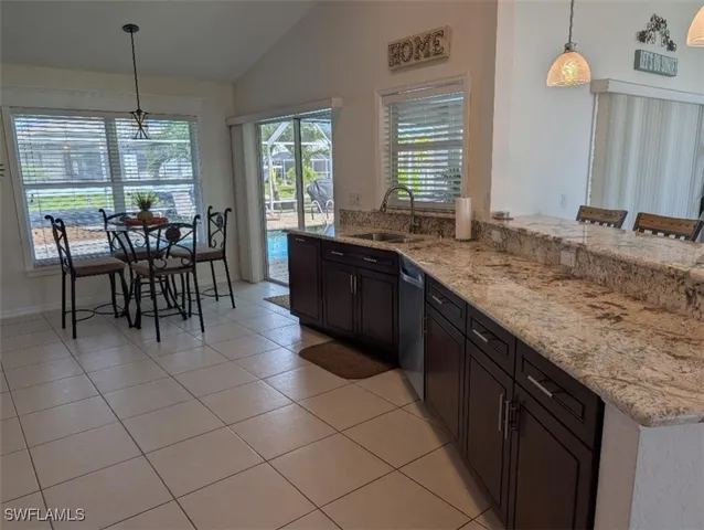 a large kitchen with granite countertop a sink and a wooden floor