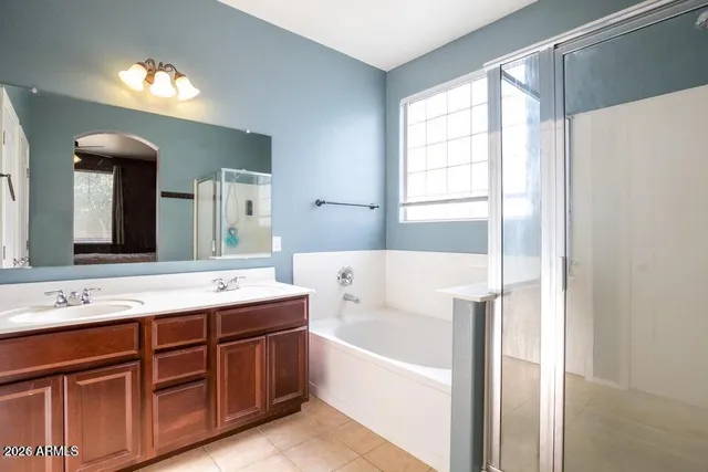 a bathroom with a tub a sink and a mirror