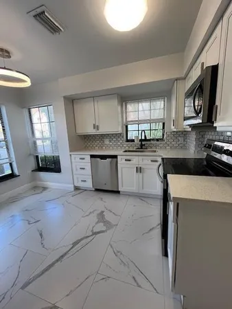 a view of a kitchen with refrigerator and windows