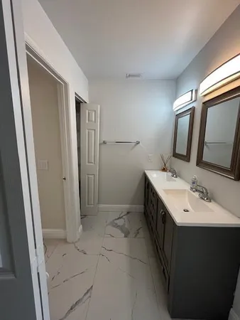 a bathroom with a toilet sink and mirror