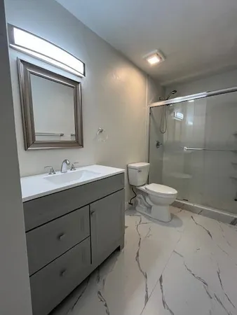 a bathroom with a toilet sink and mirror