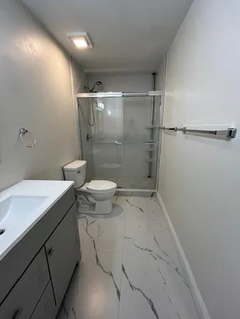 a bathroom with a sink a toilet and shower