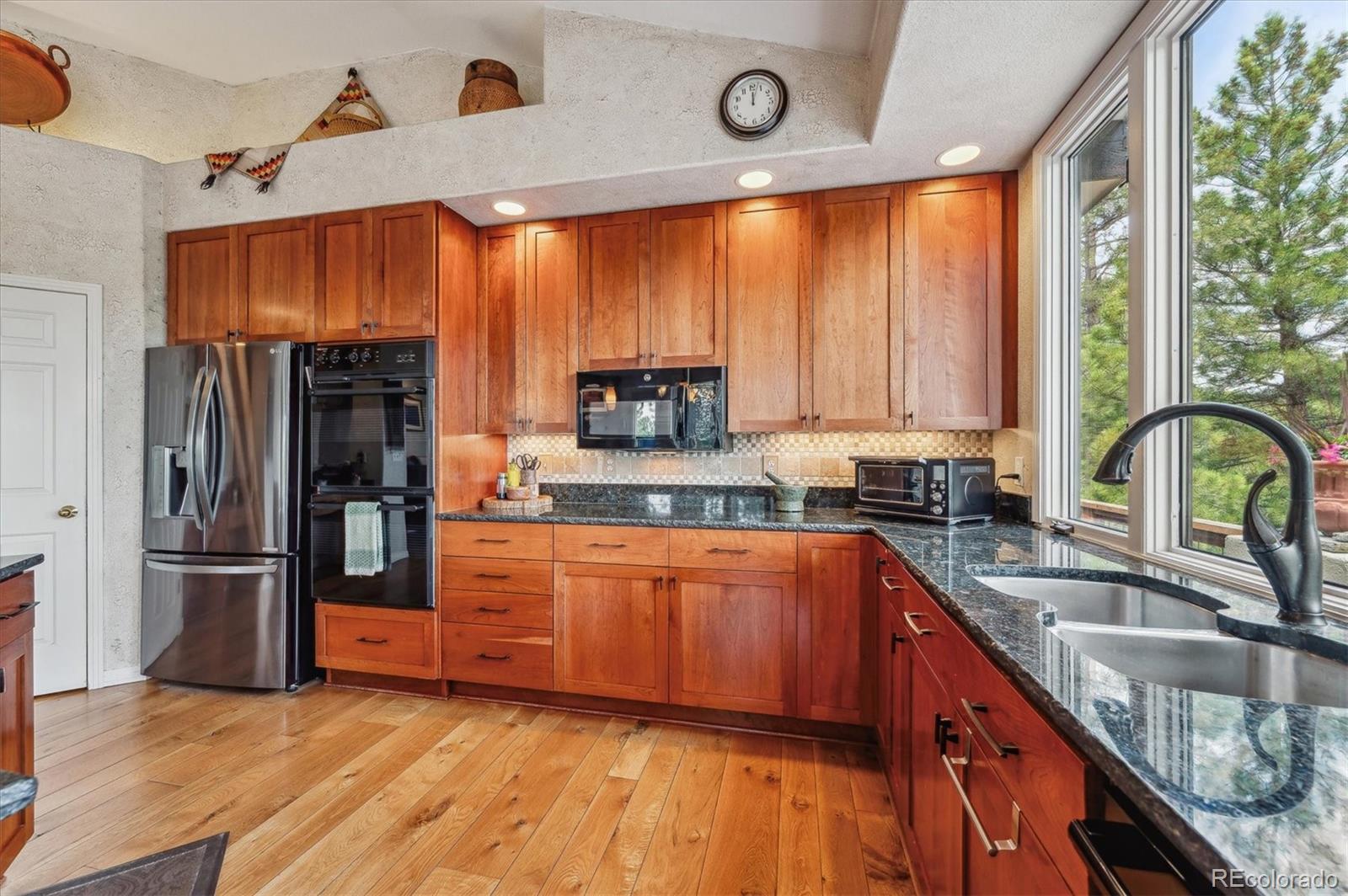 1784 Prima Lane Evergreen, CO 80439 - Photo 14 of 37 a large kitchen with stainless steel appliances granite countertop a refrigerator a sink dishwasher a stove and a refrigerator