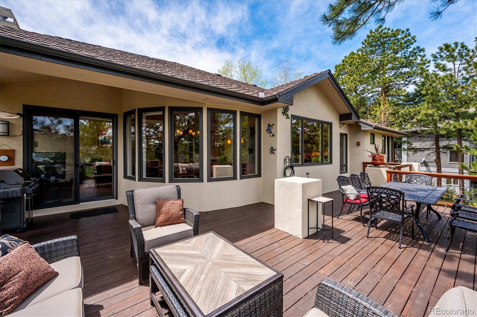 1784 Prima Lane Evergreen, CO 80439 - Photo 15 of 37 a view of a patio with table and chairs potted plants with wooden floor and fence
