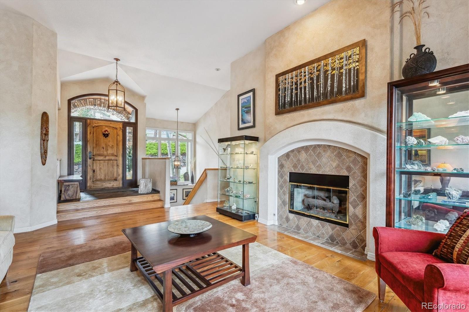 1784 Prima Lane Evergreen, CO 80439 - Photo 6 of 37 a living room with furniture a fireplace and a floor to ceiling window