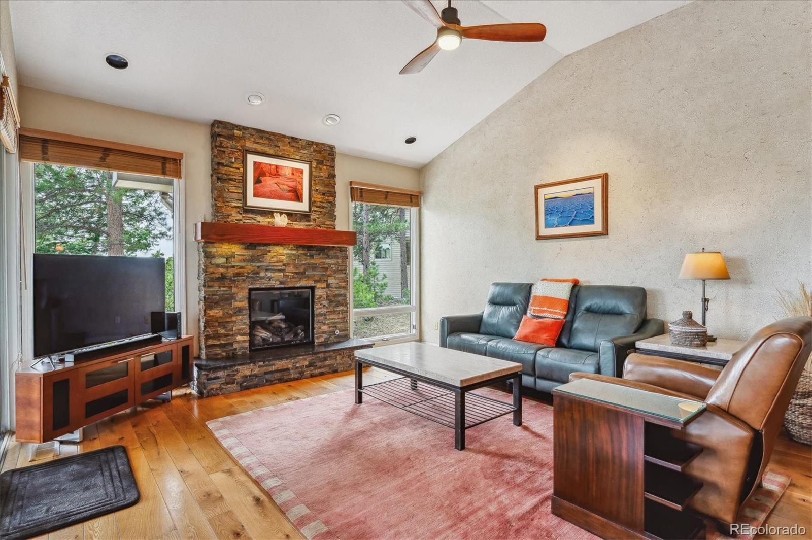 1784 Prima Lane Evergreen, CO 80439 - Photo 9 of 37 a living room with furniture a flat screen tv and a fireplace