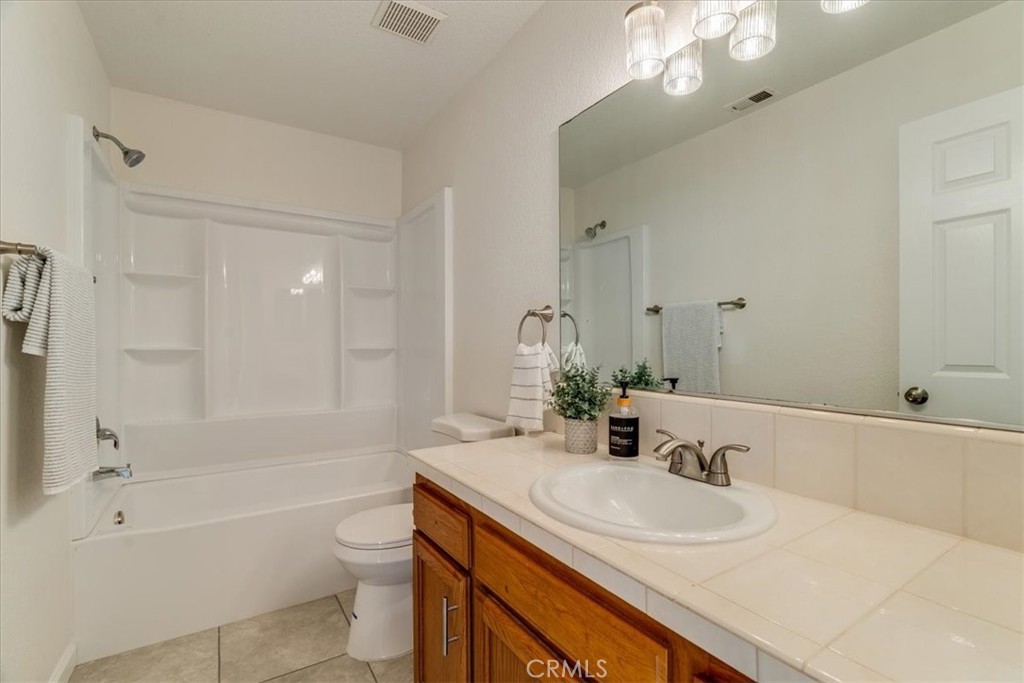 646 Shady Lane Santa Maria, CA 93455 - Photo 34 of 44 a bathroom with a sink a toilet a mirror a bathtub and shower