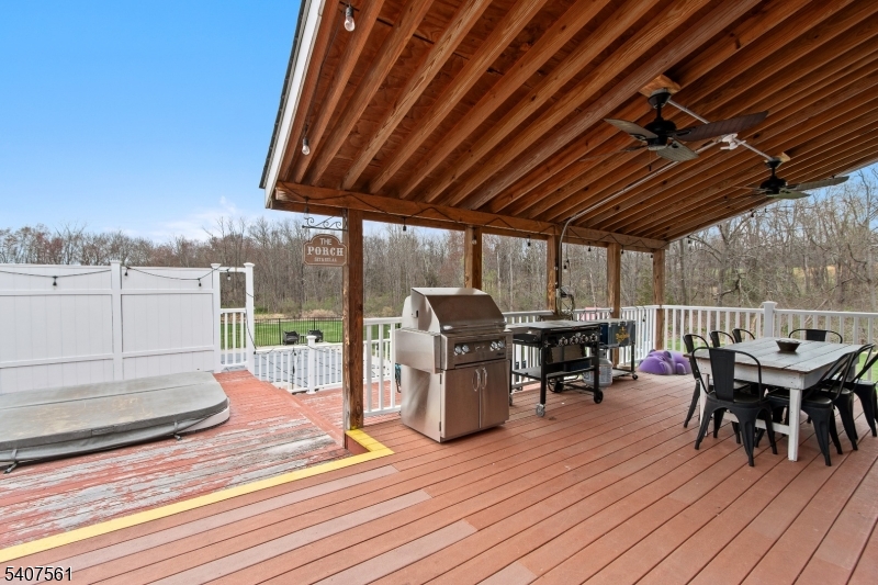 30 Lanning Road Blairstown, NJ 07825 - Photo 30 of 40 a view of a roof deck with table and chairs a barbeque with wooden floor and fence