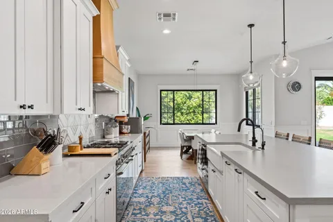a kitchen with kitchen island granite countertop a sink appliances and cabinets