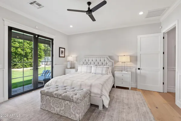 a bedroom with a bed painting and wooden floor