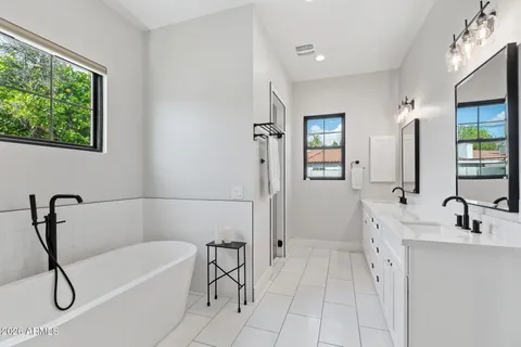 a bathroom with a tub sink and mirror