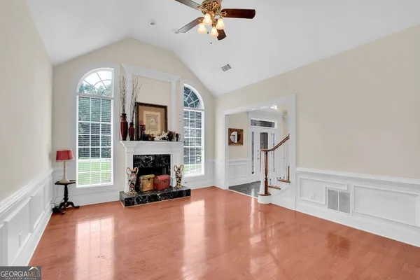 a view of a livingroom with a fireplace a chandelier a wooden floor and a fireplace