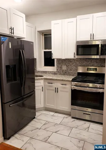 a kitchen with stainless steel appliances and granite countertop a stove top oven