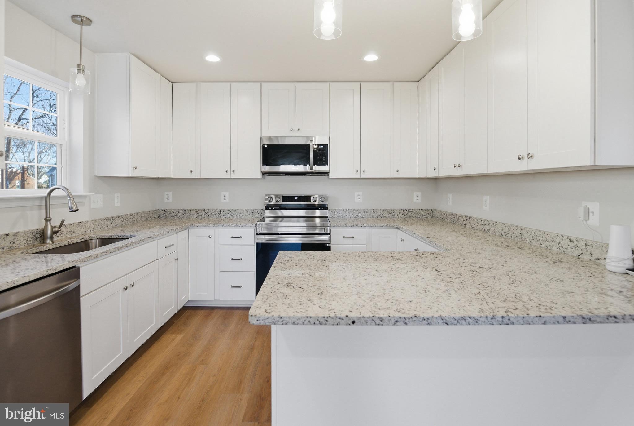 504 Cleveland Road Linthicum Heights, MD 21090 - Photo 16 of 54 a kitchen with granite countertop white cabinets and white stainless steel appliances