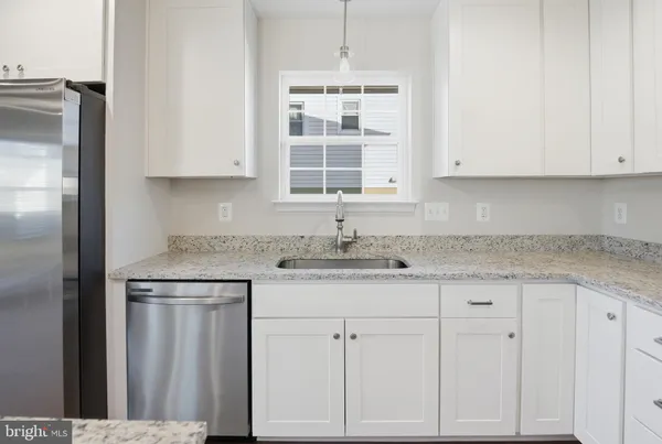 a kitchen with granite countertop white cabinets and sink