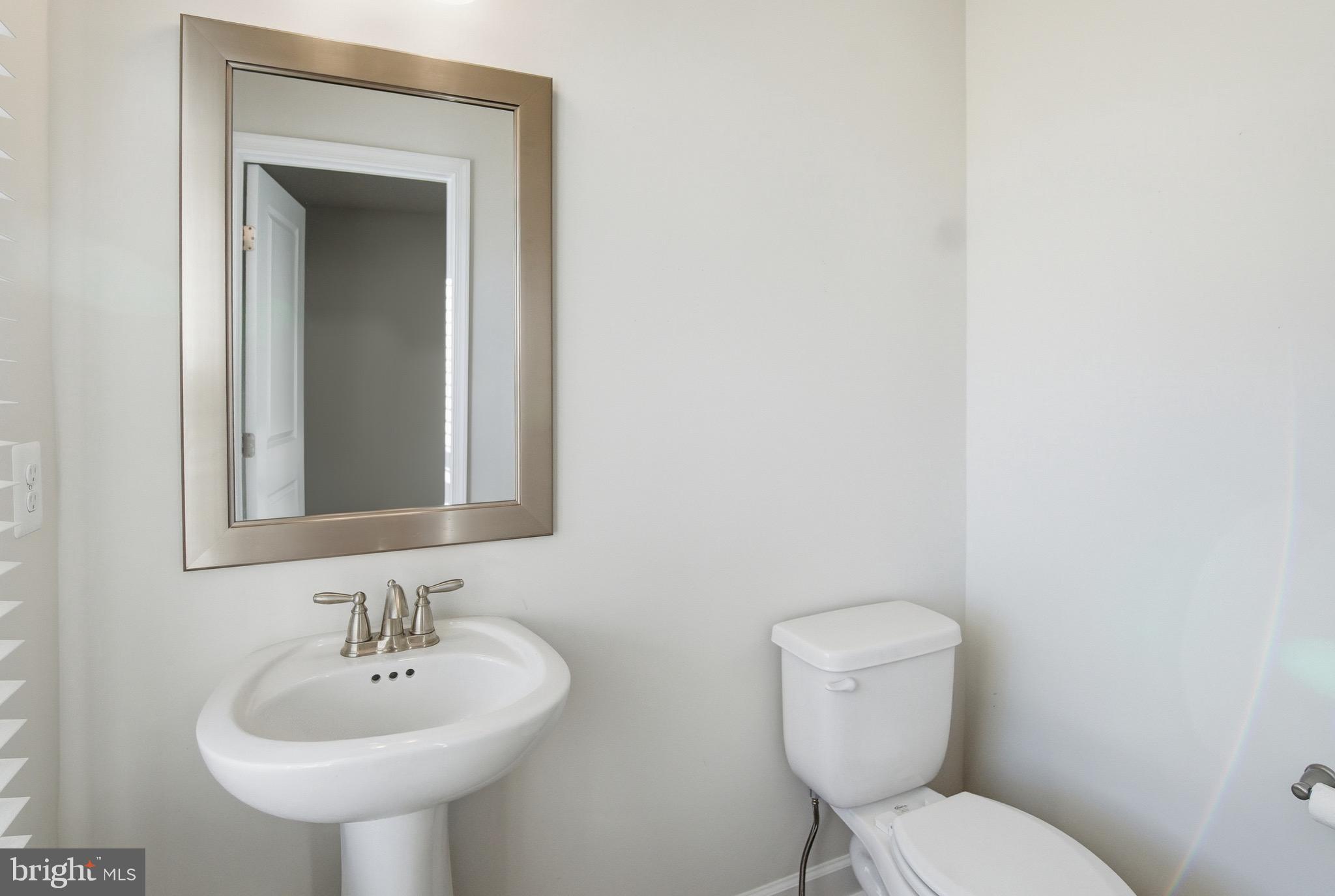 504 Cleveland Road Linthicum Heights, MD 21090 - Photo 19 of 54 a bathroom with a toilet sink and mirror
