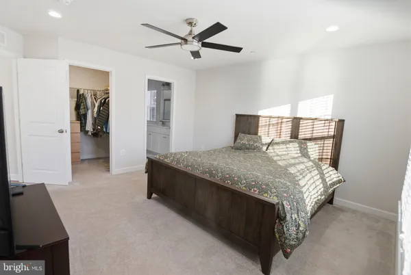 a spacious bedroom with a bed and a chandelier
