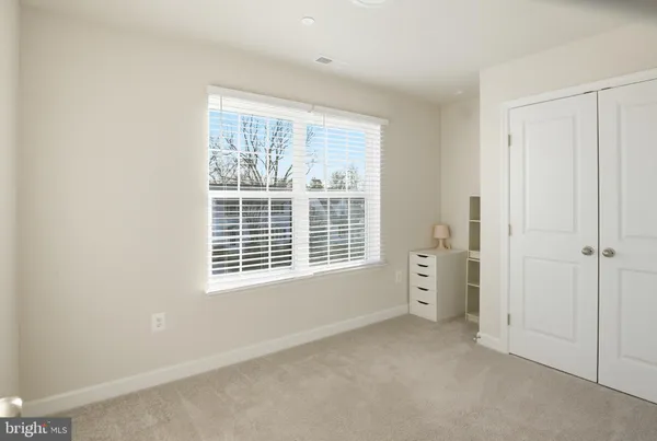 a view of an empty room with a window and a bathroom